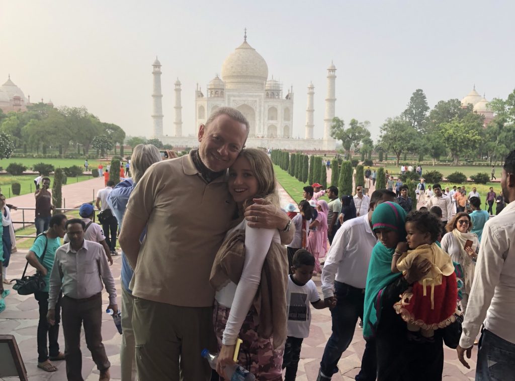 A man and woman posing in front of the taj mahal.