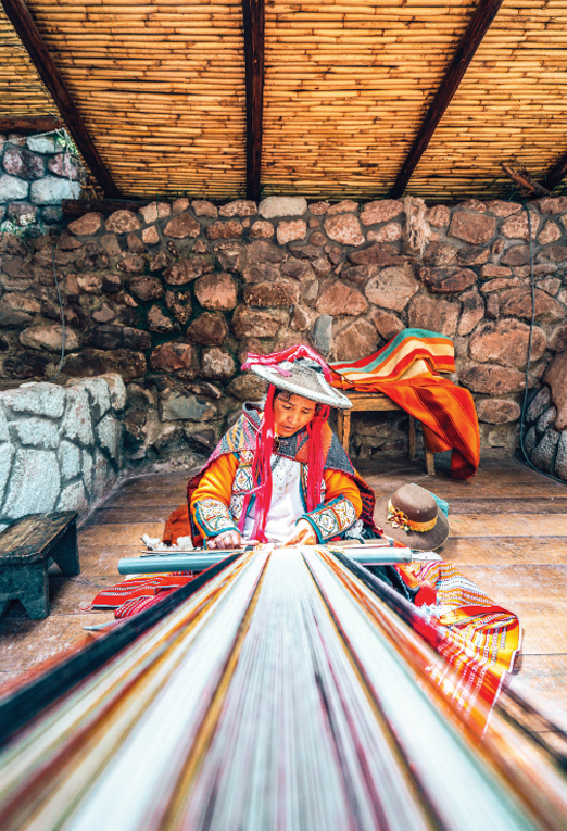 Image of a woman making hand woven fabric