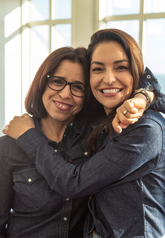 Image of 2 woman hugging and smiling