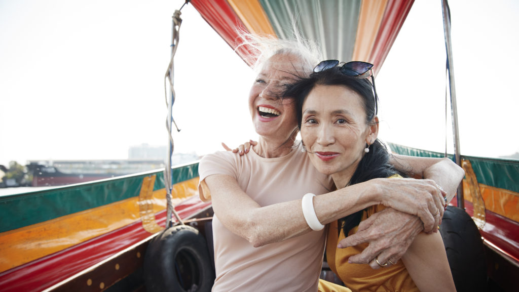 Two woman sitting in a boat, white label travel product the Travel Corporation