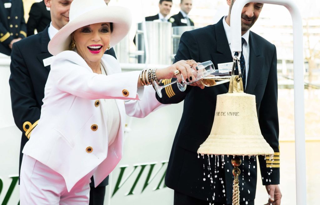A woman in a white hat is pouring water into a bell.