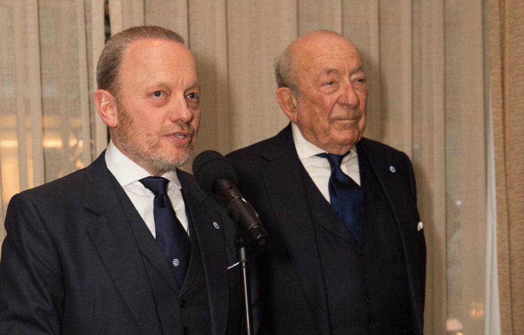 Two men in suits standing next to each other.