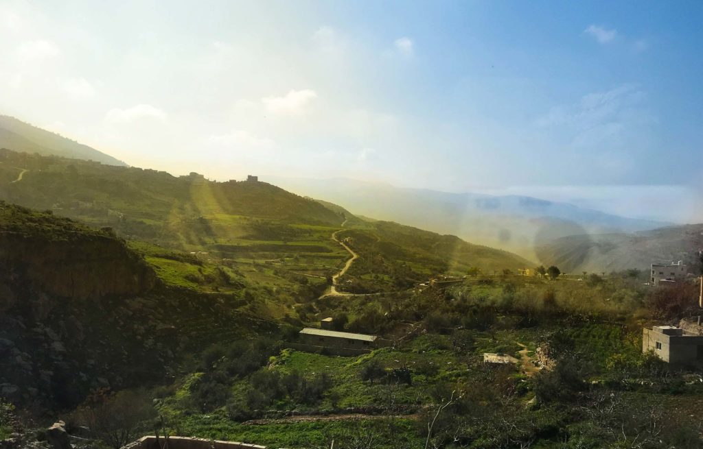 A view of a valley from a train window.