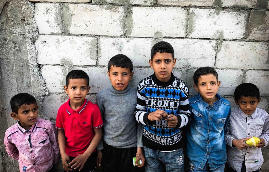 A group of boys standing in front of a wall.
