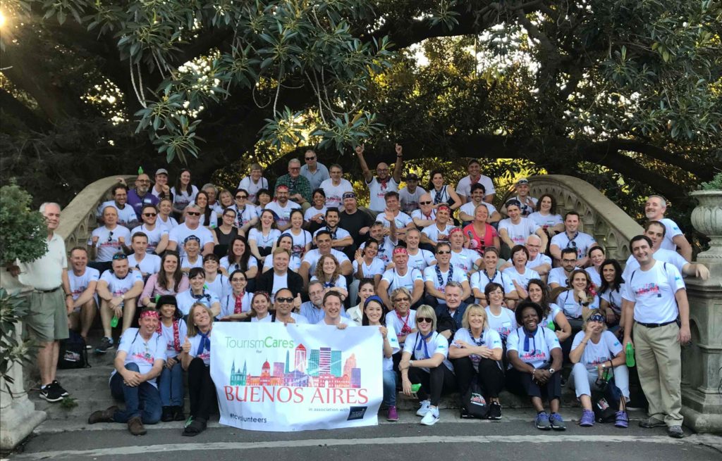 A group of people posing for a photo in front of a tree.