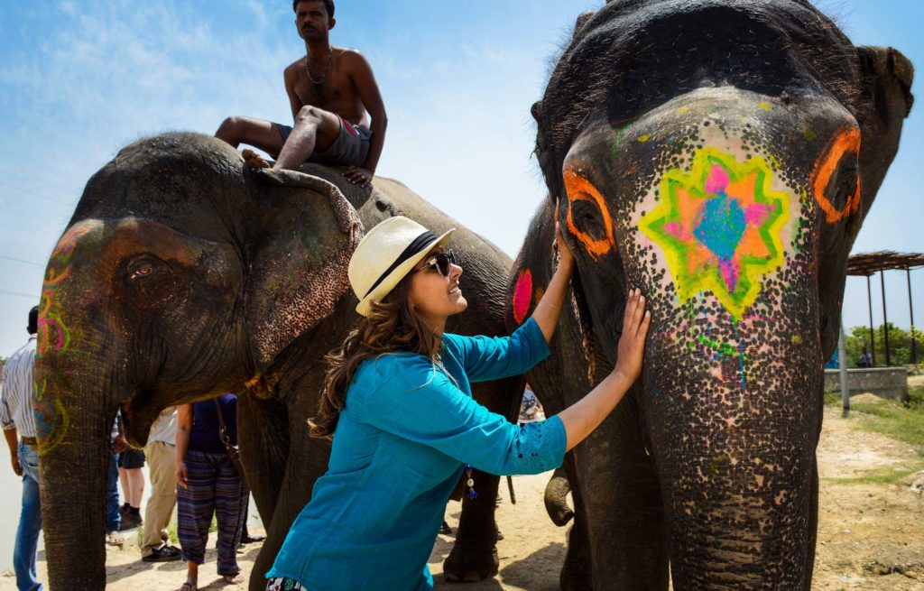A woman petting an elephant.