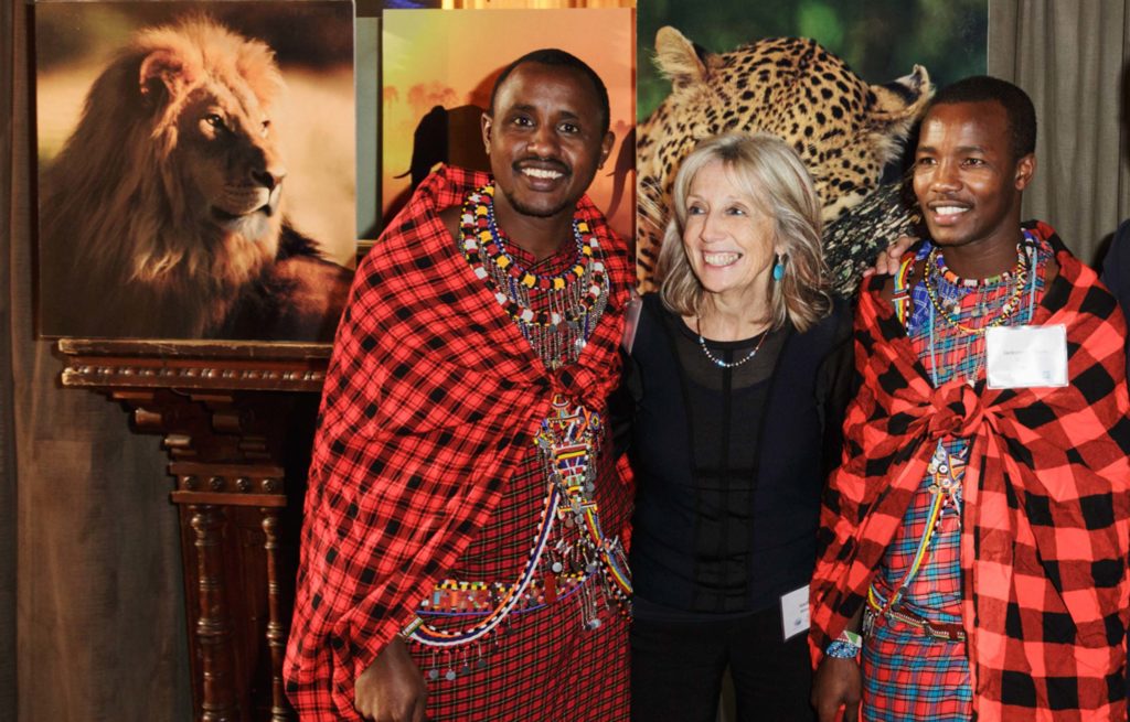 A group of people posing for a photo with a lion.